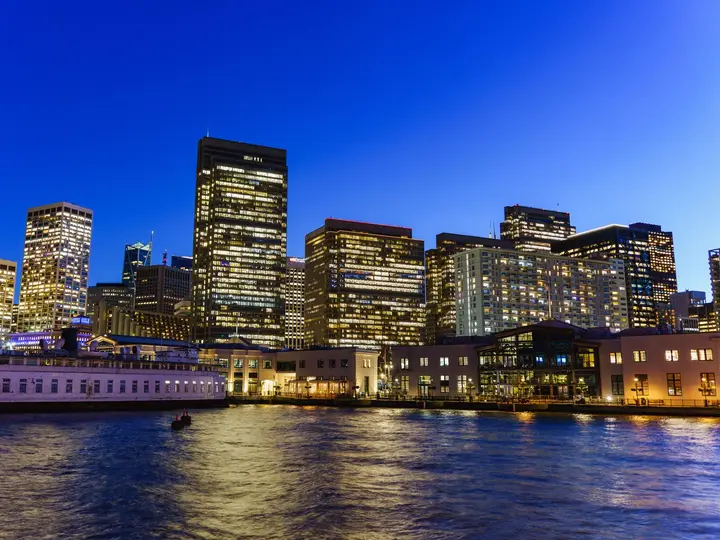 A city skyline lit up at dusk